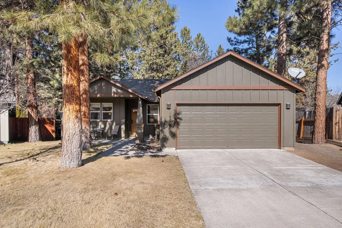 The front porch and landscaped yard create a welcoming entrance, with mature trees offering shade and privacy. The view hints at a peaceful, quiet neighborhood setting ideal for restful evenings and enjoying nature.